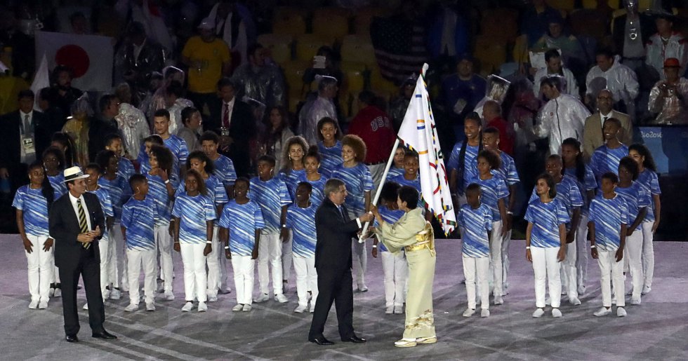 El gobernador de Tokio, Yuriko Koike acepta la bandera de los Juegos Olímpicos de Thomas Bach, Presidente del Comité Olímpico Internacional (COI), ante la mirada de Eduardo Paesel, alcalde de Río de Janeiro.