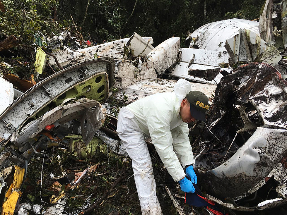 Un agente de la policía trabaja cerca de los restos del avión siniestrado en La Unión (Colombia).