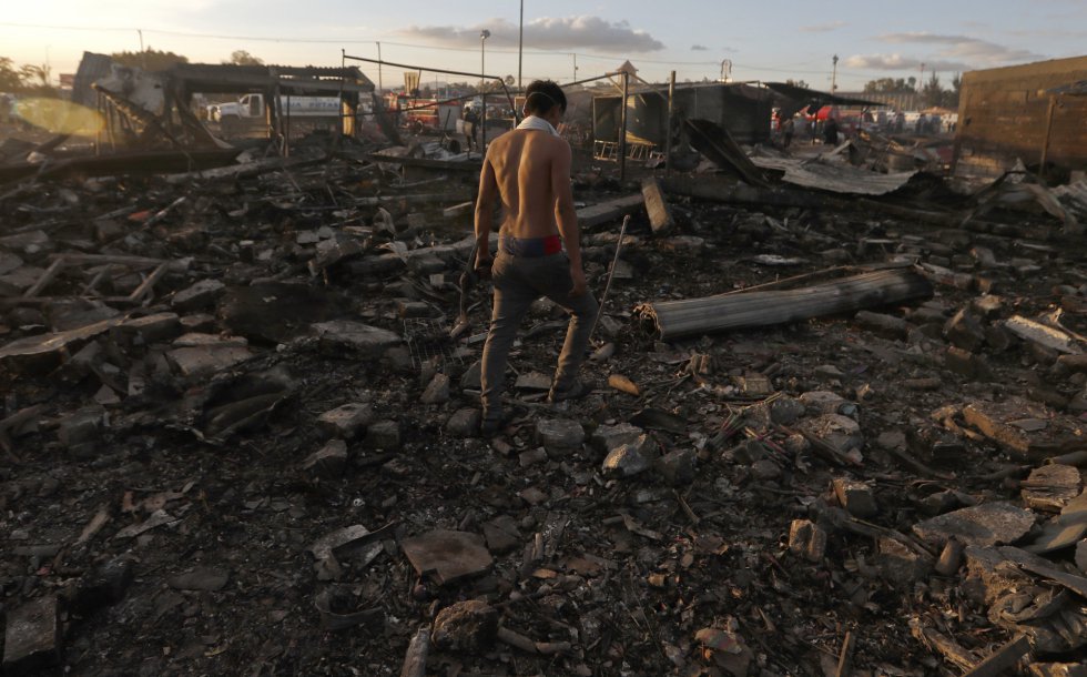 Un joven camina en los escombros del mercado de pirotecnia de Tultepec después de la explosión de este martes