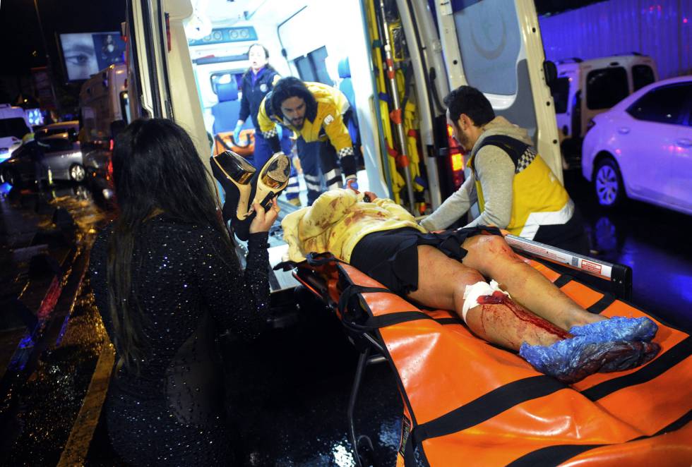 Personal sanitario trasladan en una ambulancia a una víctima del ataque en la discoteca Reina.