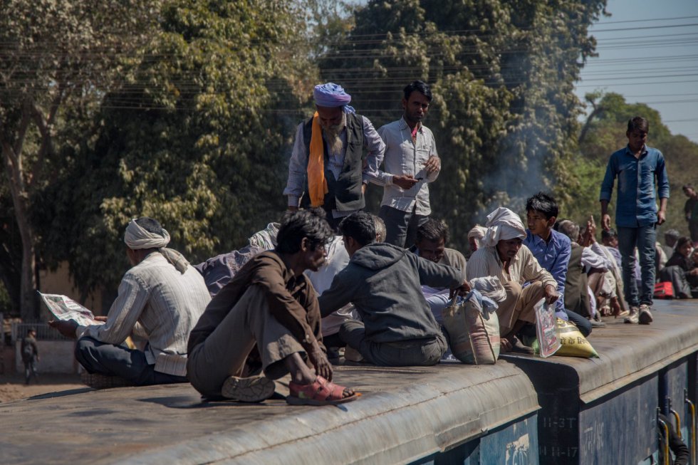 Escena cotidiana en Sabalgarh. Durante el cruce con el 52172, estirar las piernas, charlar con los viajeros o leer la prensa son imagen común entre los pasajeros senior del techo de un vagón.