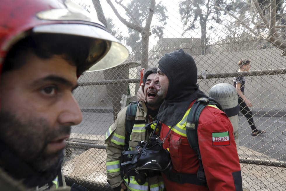 Bomberos iraníes reaccionan al saber que varios de sus compañeros quedaron atrapados en el derrumbe que siguió a un grave incendio en el edificio Plasco en Teherán.