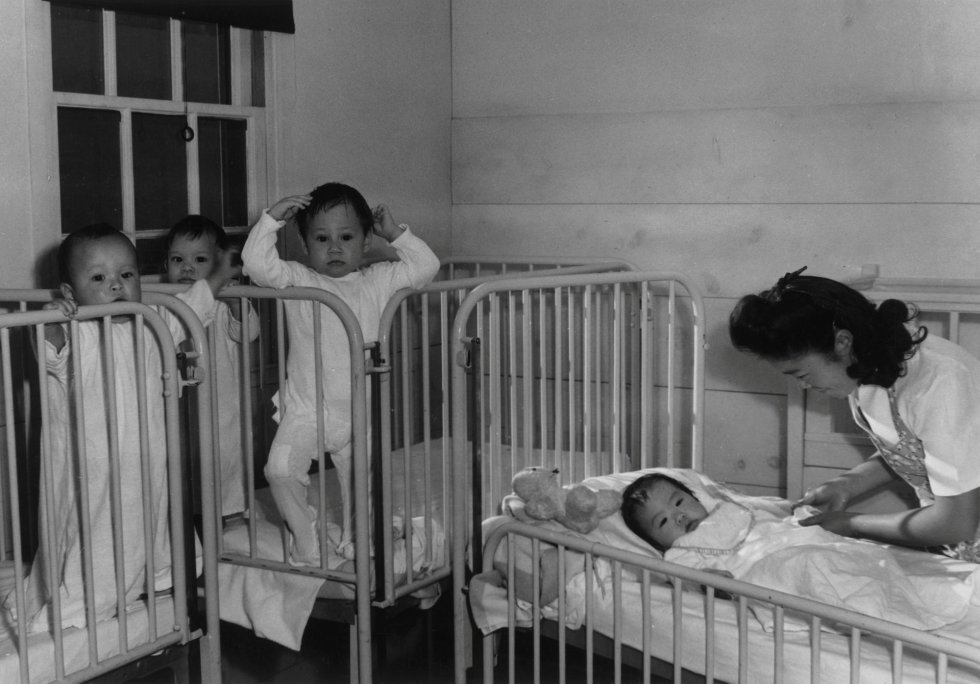 Los más de 10.000 habitantes que llegó a tener Manzanar pusieron en pie una auténtica ciudad para sobrevivir al confinamiento, como una escuela, una guardería, un hospital, varios comercios y hasta un cementerio. En la image, una enfermera atiende a cuatro bebés en cunas del Centro de Reubicación de Guerra, 'Manzanar', en 1943 en California.