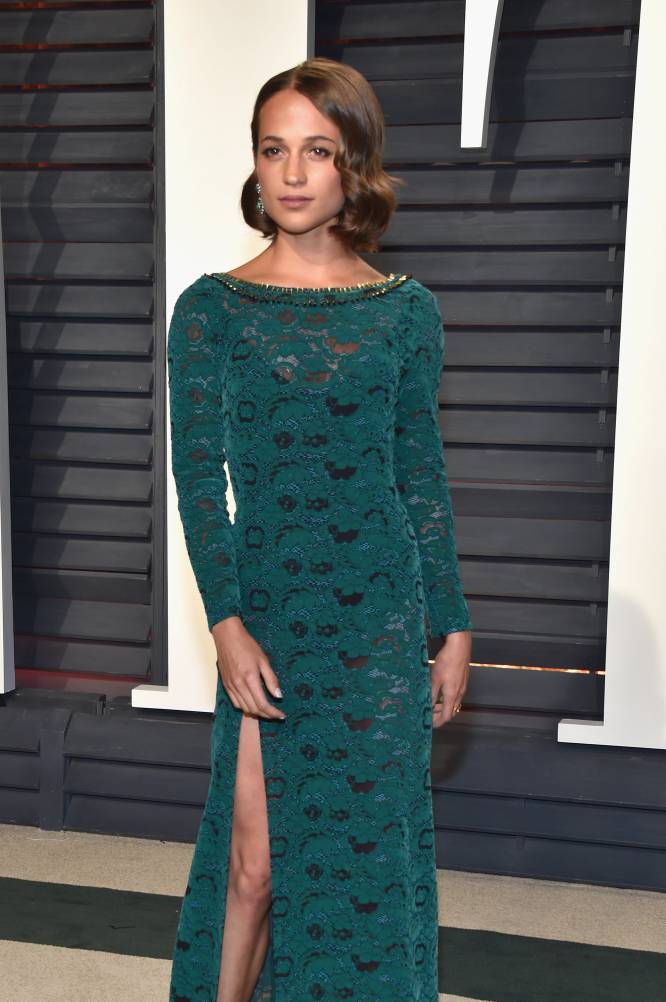 La actriz Alicia Vikander con un vestido de encaje de color turquesa.