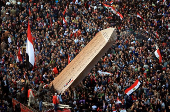 Los egipcios llevan a la plaza Tahrir un obelisco con los nombres de los fallecidos en la revuelta del año pasado. / MAHMUD HAMS (AFP)