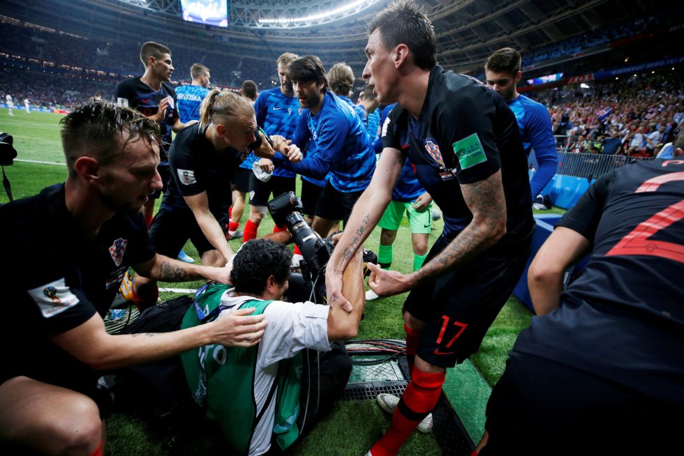 Diante da situação, mais jogadores se empenharam na tarefa de levantar o fotógrafo.