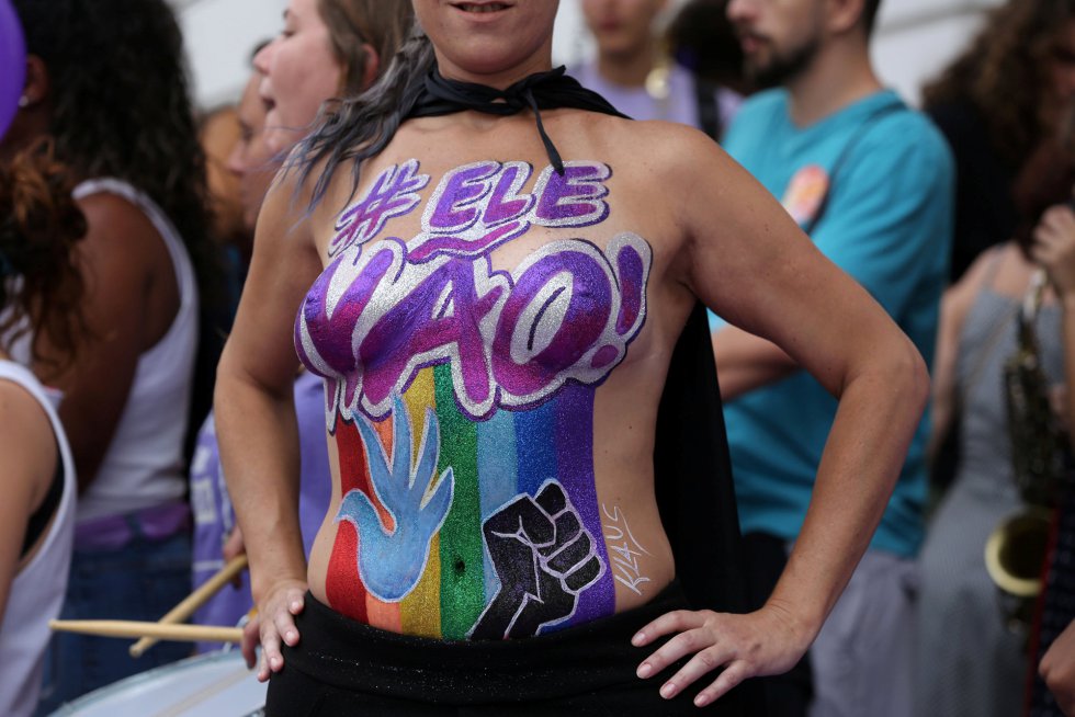 Foi um Carnaval lilÃ¡s, a cor do feminismo. Na foto, uma manifestante com o corpo pintado: #elenÃ£o.