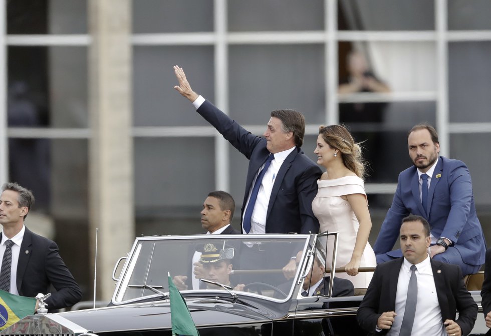 O presidente Jair Bolsonaro desfila por BrasÃ­lia acompanhado da primeira-dama, Michelle, e de um de seus filhos, Carlos Bolsonaro. 