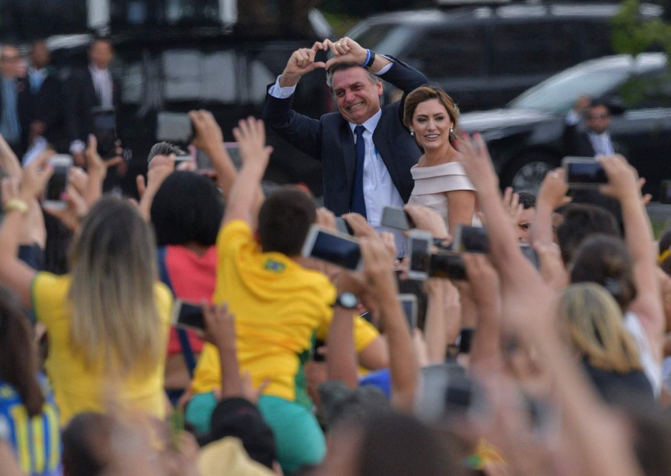Seguidores de Bolsonaro acompanham o desfile do cortejo presidencial.