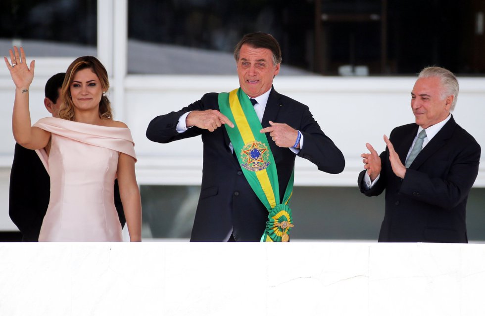 Bolsonaro gesticula ao lado da esposa Michelle e do ex-presidente Michel Temer. 