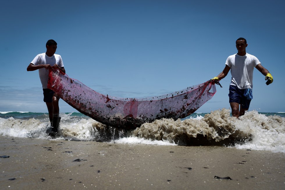 Praia do Paiva, Cabo de Santo Agostinho, Pernambuco. Voluntários fazem a remoção de porções de óleo com rede improvisada