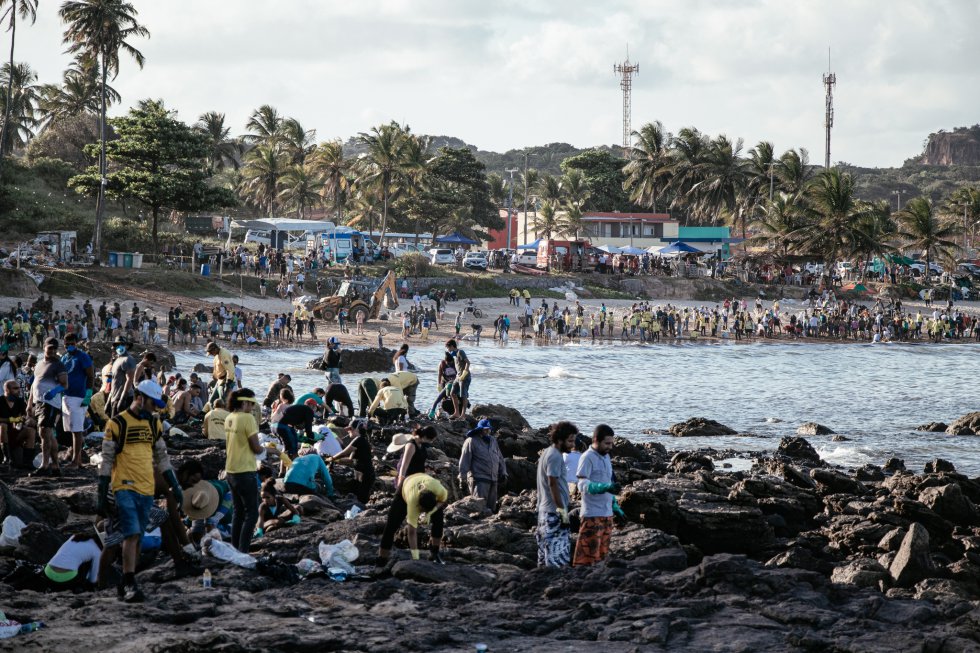 Uma multidão de voluntários se esforça para retirar o óleo da praia de Itapoama, em Cabo de Santo Agostinho, Pernambuco.