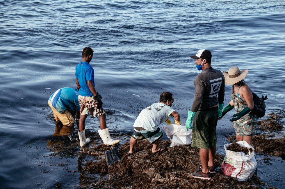 A retirada do óleo da costa do Nordeste é um esforço voluntário dos moradores das cidades costeiras. Praia de Itapoama, em Cabo de Santo Agostinho, Pernambuco.