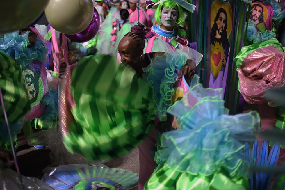 Brincantes da Mangueira vestindo seus trajes na concentração.