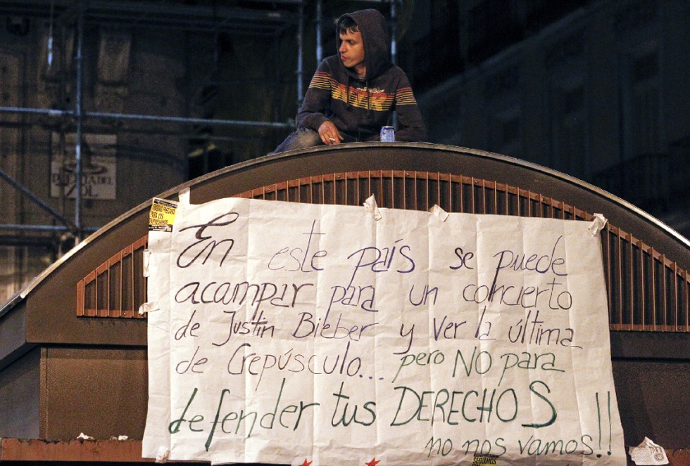 Los manifestantes no se van de la Puerta del Sol y se quejan, como dicen en esta pancarta que han colocado en un quiosco, que se pueda acampar en la calle para coger entradas para un concierto o ver una pelicula y no para defender los derechos de los ciudadanos.