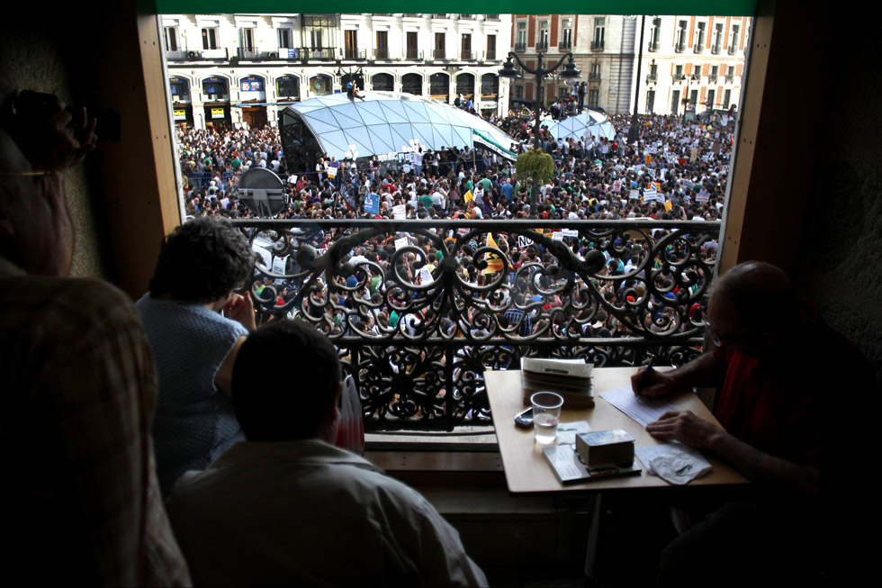 La Puerta del Sol, repleta de manifestantes, en una imagen tomada desde una cafetería.