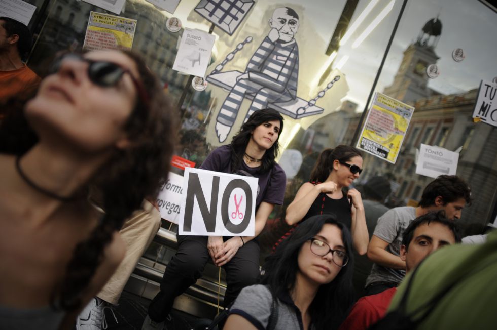 Una indignada porta una pancarta contra los recortes en la Puerta del Sol de Madrid.