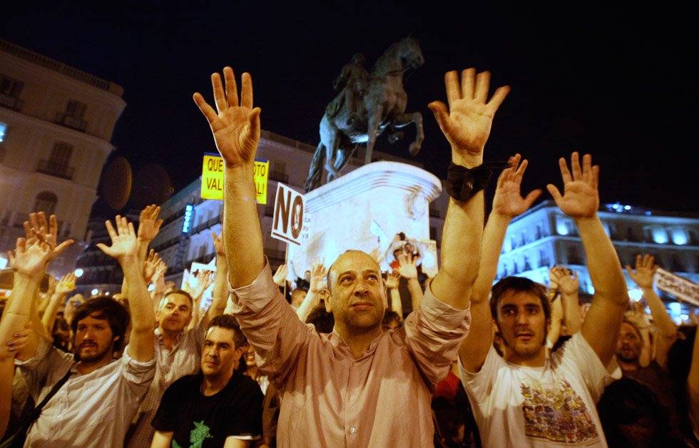 Indignados levantan sus manos durante la protesta en la Puerta del Sol.