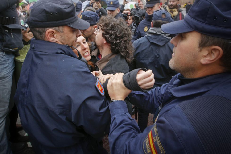 El colectivo antidesahucio de Madrid ha convocado tres escraches esta semana. Uno en la Junta Municipal del Distrito de Puente de Vallecas, a la diputada Eva Durán, y dos más en las casas de Belén Bajo Prieto y Soraya Sáenz de Santamaría. En los dos últimos hubo forcejeos, la policía separó a activistas e identificó a participantes en la marcha. En la imagen, la policía separa a dos manifestantes de la protesta de Bajo Prieto.