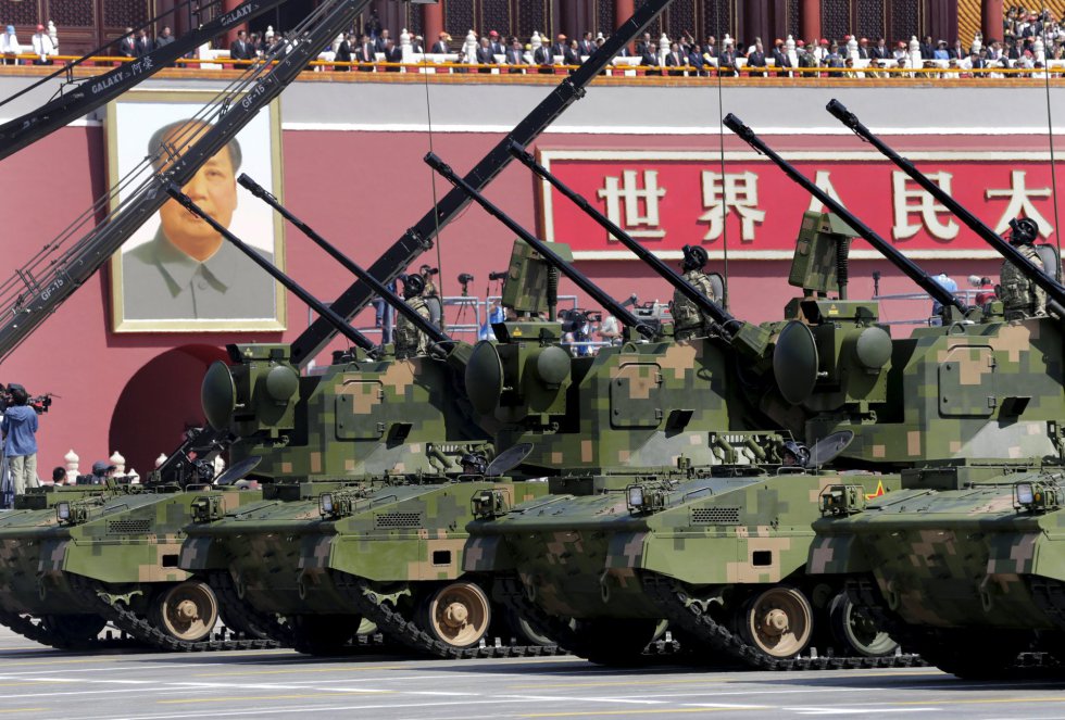 Carros blindados, vehículos pertenecientes a la artillería antiaérea, pasan delante de las autoridades chinas y el retrato del histórico líder Mao Zedong, durante el desfile militar.