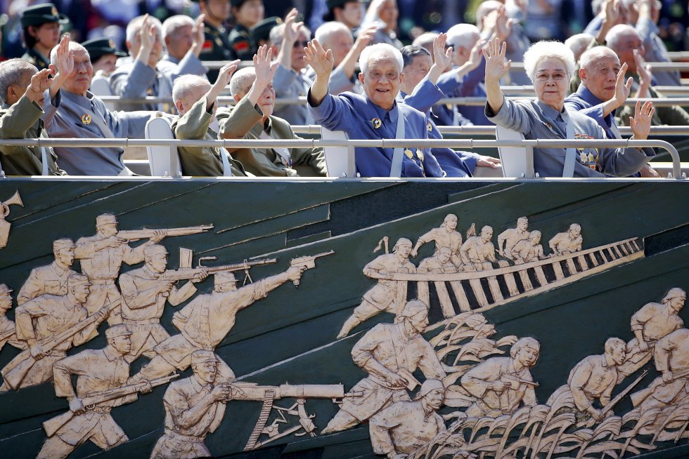 Un grupo de veteranos de guerra saluda, desde sus asientos en la plaza de Tiananmen, durante el desfile militar.