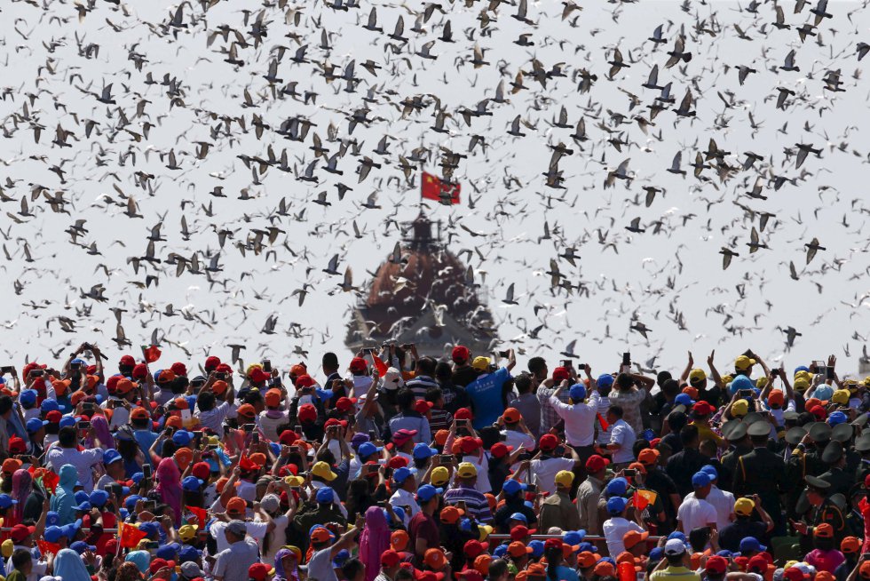Las autoridades chinas liberan palomas mientras una multitud mira hacia el cielo. El líder Xi Jinping ha anunciado este jueves que reduciría el número de soldados en 300.000 efectivos.