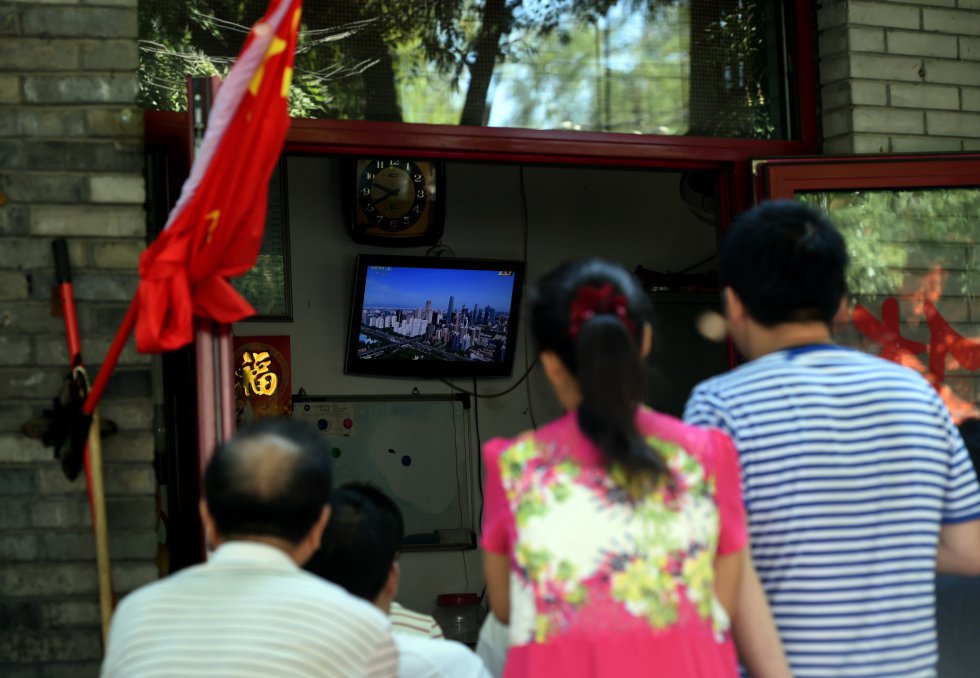 Unos ciudadanos chinos se reúnen frente al televisor para ver por la pantalla el desfile militar. China organizó una marcha para conmemorar su victoria sobre Japón y el final de la II Guerra Mundial a la que no acudió ningún líder occidental.