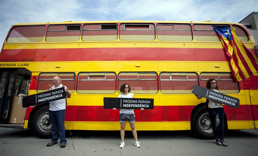 Varias personas sujetan carteles durante la celebración de la Diada por las calles de Barcelona.