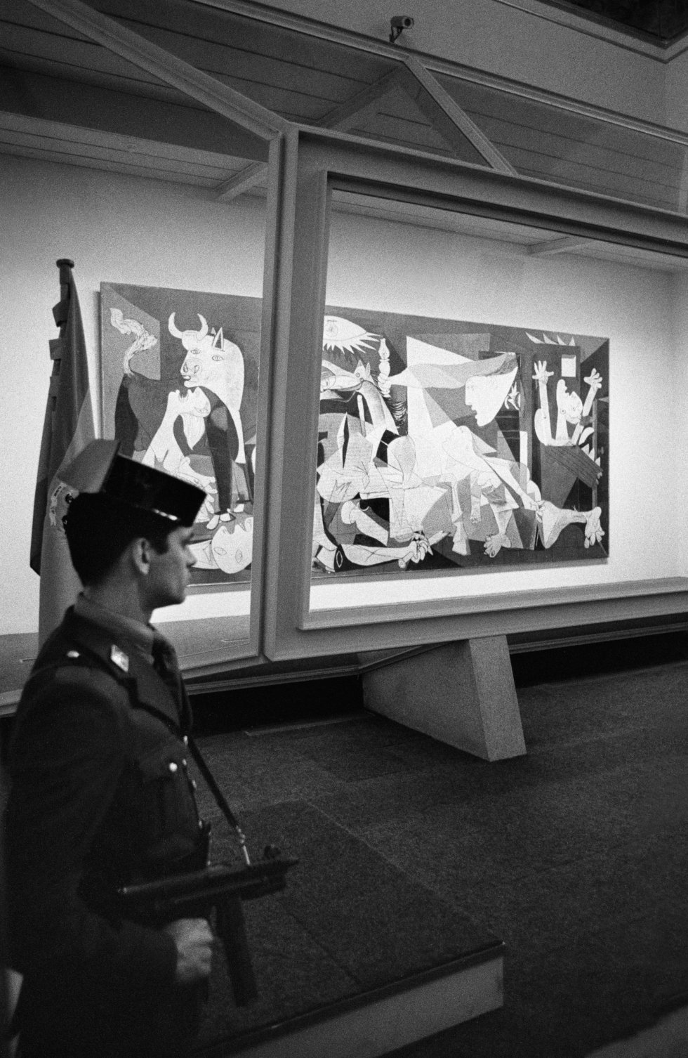 El 'Guernica', de Picasso, vigilado por un guardia civil en el Casón del Buen Retiro, en Madrid, durante la presentación por la vuelta de la obra a España. La imagen fue tomada el 23 de octubre de 1981.