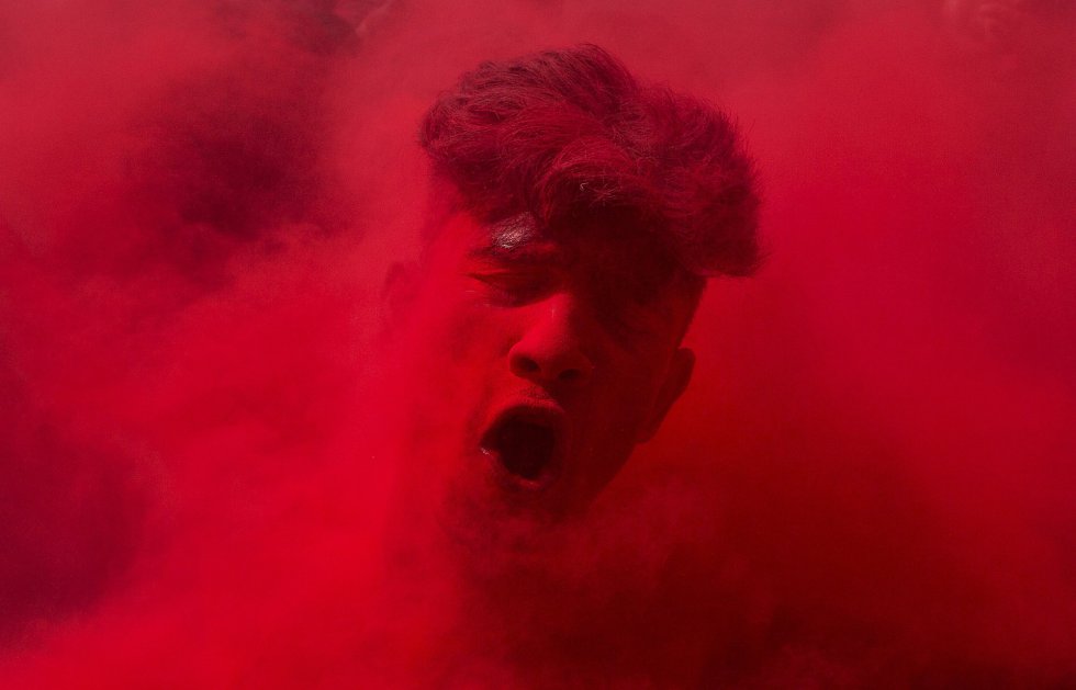 Los polvos de color rojo cubren a uno de los participantes en el festival de Gauhati, India.