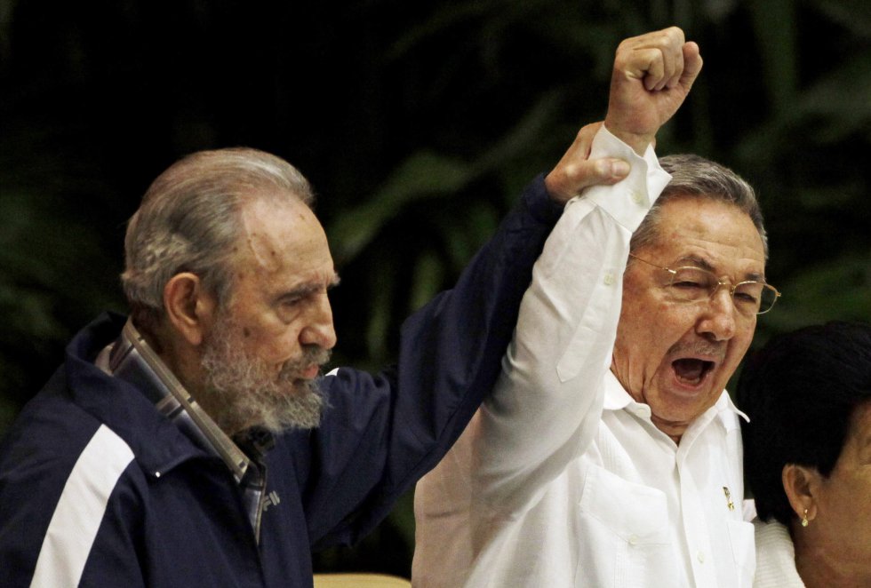 Fidel Castro levanta el brazo de su hermano Raúl mientras cantan la Internacional durante el 6º Congreso del Partido Comunista cubano en La Habana, el 19 de abril de 2011. Castro designó a su hermano para sucederle en el poder tras caer enfermo en julio de 2006.