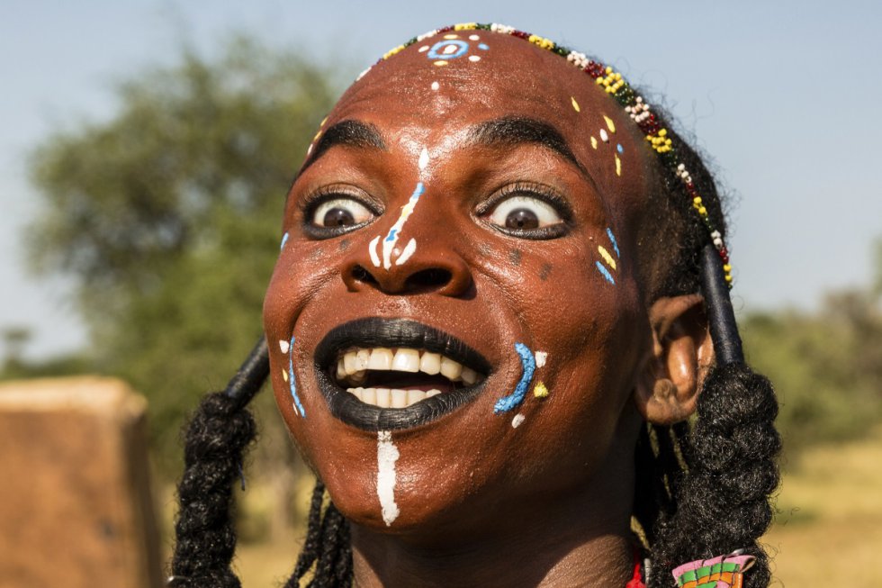 Este wodaabe se está mirando en un espejo de bolsillo, un accesorio indispensable para los hombres de la tribu. Se ha afeitado parte de la cabeza para alargar la frente y está probando a mover los ojos y enseñar los dientes, un aspecto de la danza que muestra los rasgos más deseables para las mujeres wodaabes.