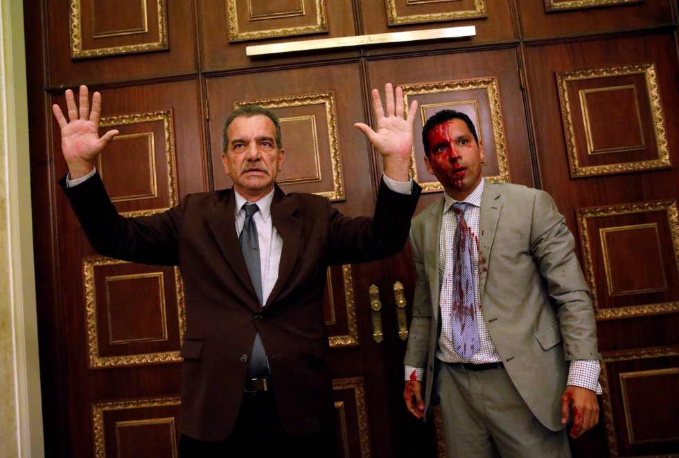 El diputado opositor Luis Stefanelli (izda.) levanta las manos junto al también diputado de la oposición Leonardo Regnault.