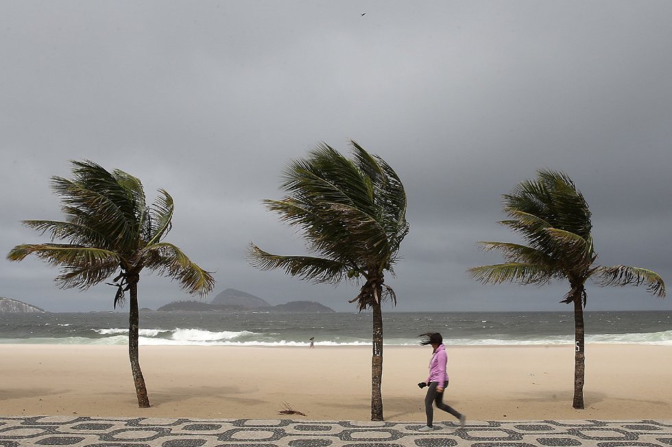Una mujer camina en la playa de Ipanema durante la llegada de un frente frío con vientos de 80kmh el pasado martes 18 de julio de 2017, en Río de Janeiro (Brasil).