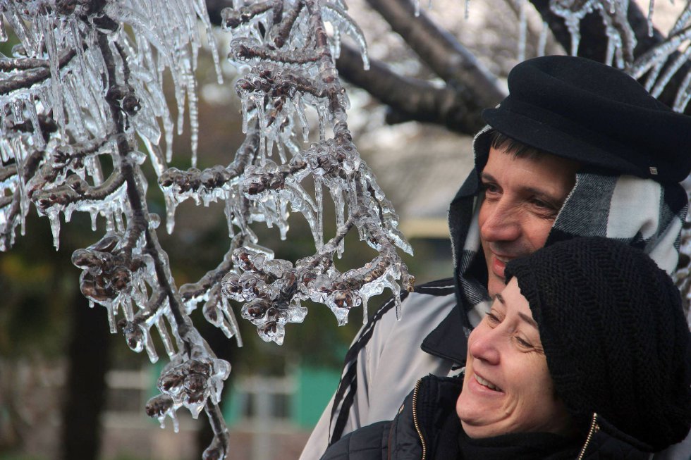 Fotografía cedida por el portal On Jack que muestra a turistas posando junto a árboles con nieve el pasado martes 18 de julio de 2017, en São Joaquim, en el estado de Santa Catarina (Brasil).
