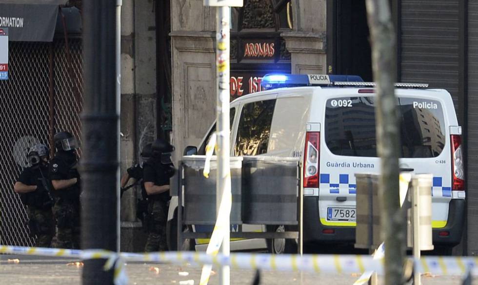 Miembros de la policía permanecen en la puerta de un restaurante donde supuestamente uno de los presuntos terroristas se había atrincherado.