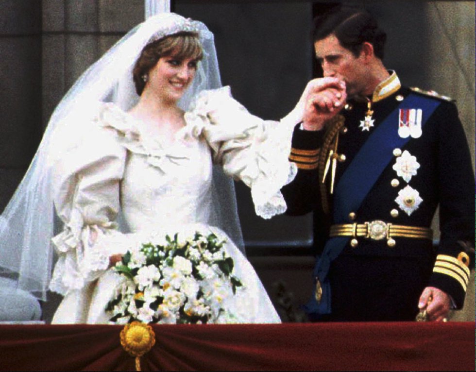 Carlos de Inglaterra besa en la mano a su flamante esposa Lady Diana Spencer, en el balcón del palacio de Buckingham, el día de su boda en 1981.