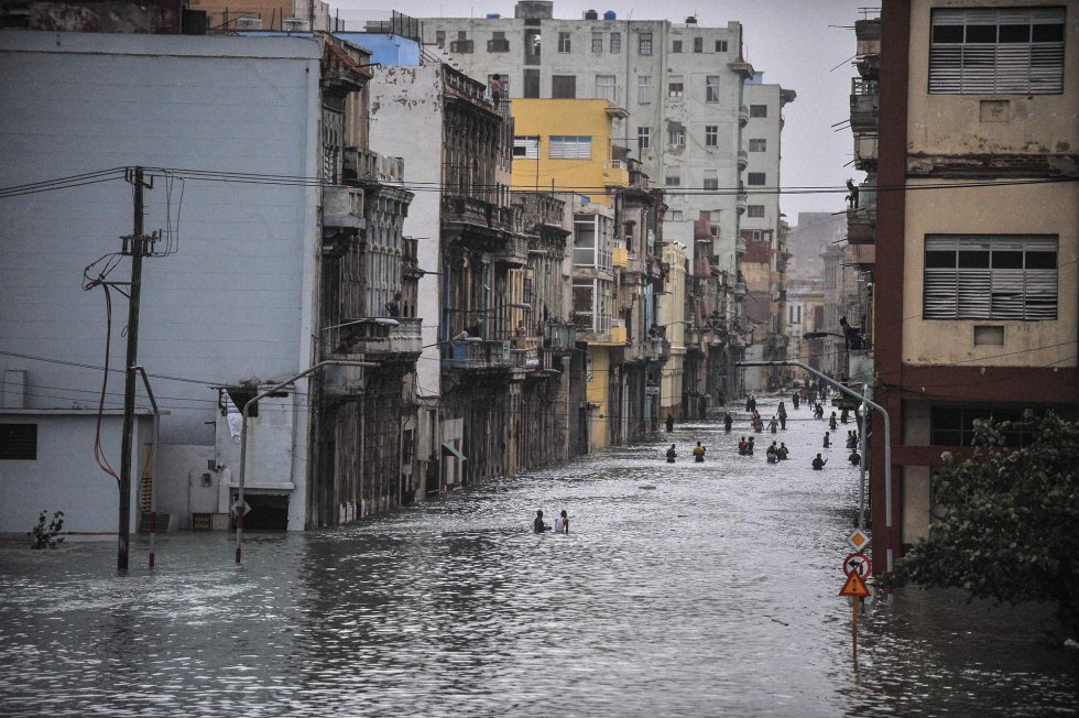 Cubanos atraviesan una calle inundada de La Habana (Cuba).
