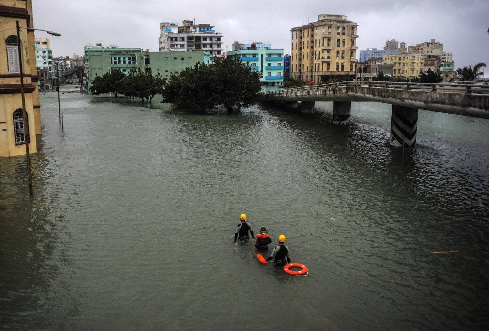 El Malecón de la Habana está inundado desde anoche y los habitantes de las viviendas próximas al mar fueron evacuados de sus casas, unas 15.000 personas en toda la capital. En la imagen, miembros de la brigada de rescaten por una calle de La Habana.