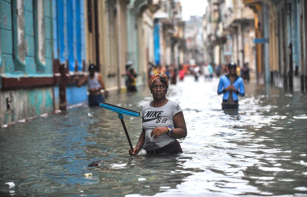 Una mujer camina por una calle inundada de La Habana (Cuba).
