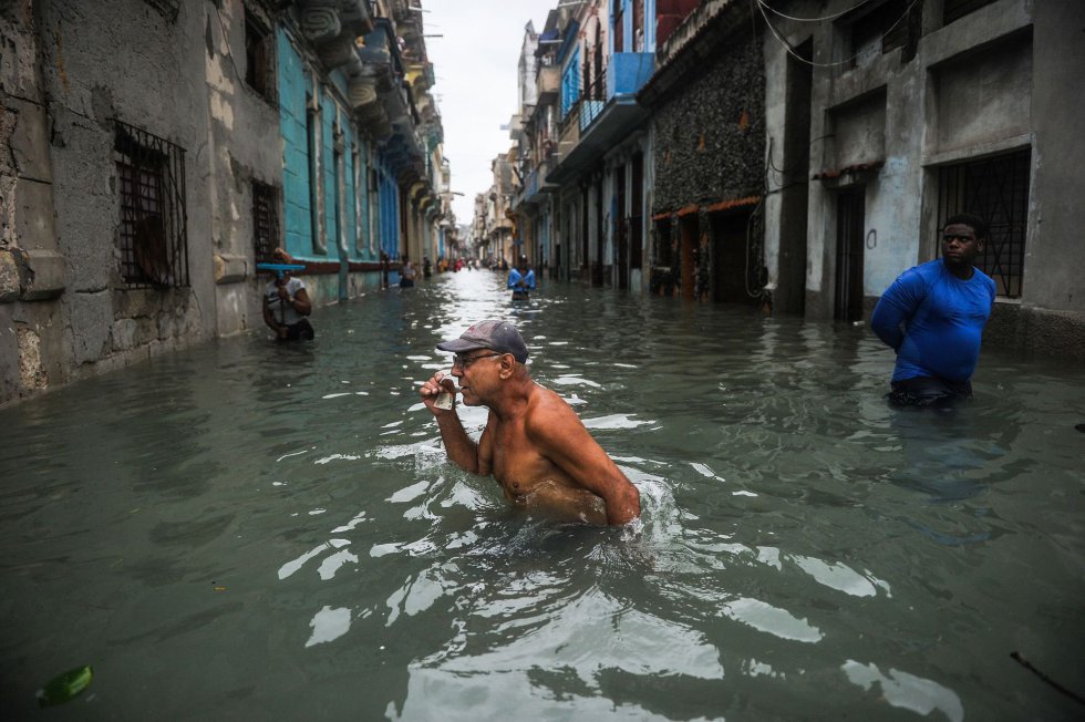 Aunque el huracán se ha alejado de la isla, se mantendrán los vientos con fuerza de tormenta tropical y se podrán dar rachas de hasta 130 kilómetros en la mitad norte de las provincias del centro y el oeste. En la imagen, un hombre camina por una calle inundada de La Habana (Cuba).