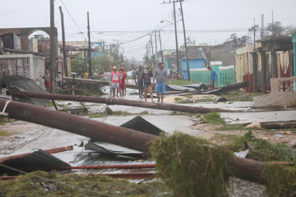 El ojo de Irma se acercó anoche peligrosamente a Cuba, a unos 45 kilómetros de Varadero, aunque hoy a las 06.00 hora local (11.00 GMT) ya se había trasladado hacia el norte, hasta situarse a unos 40 kilómetros de Cayo Hueso (Florida, EE UU). En la imagen, un grupo de gente camina por una calle dañada por el huracán en Cuba.