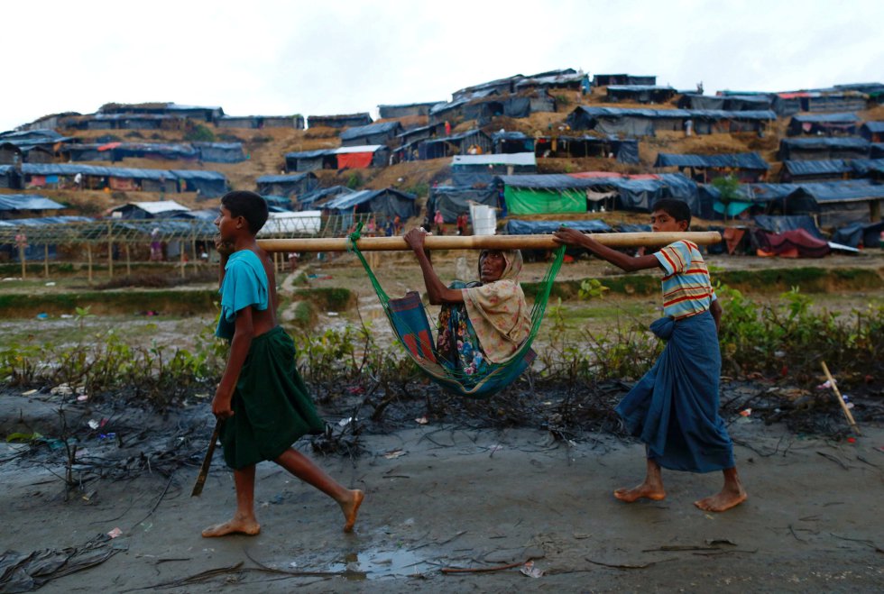 Dos niños rohingya ayudan a una anciana a desplazarse, cerca del campamento provisional de refugiados de Balukhali (Bangladés). 