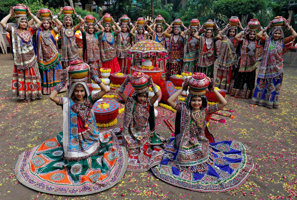 Un grupo de mujeres vestidas con trajes tradicionales posan antes de bailar Garba, un baile tradicional, al comienzo de la festividad de Navratri, en Ahmedabad (India).