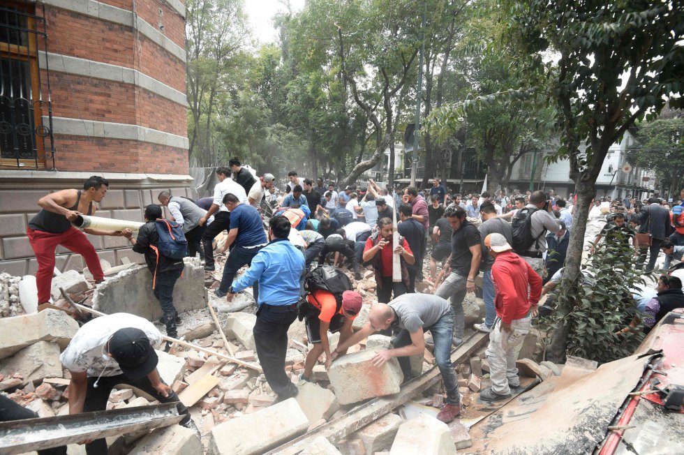 Varias personas retiran escombros de un edificio destruido a causa del terremoto, en Ciudad de México.