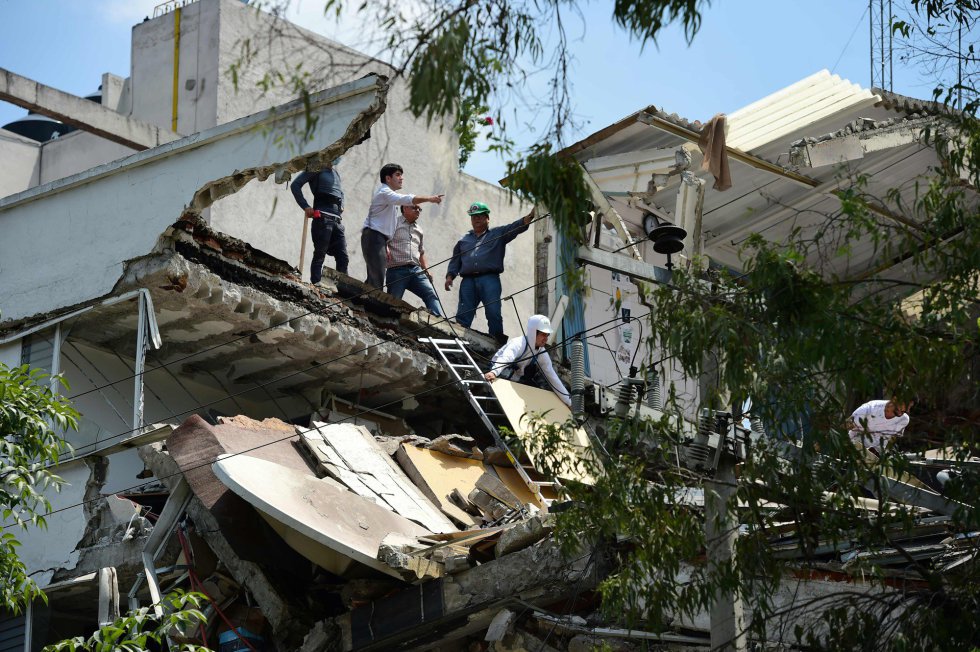 Un grupo de personas observa los daños que el terremoto ha producido en un edificio en Ciudad de México.