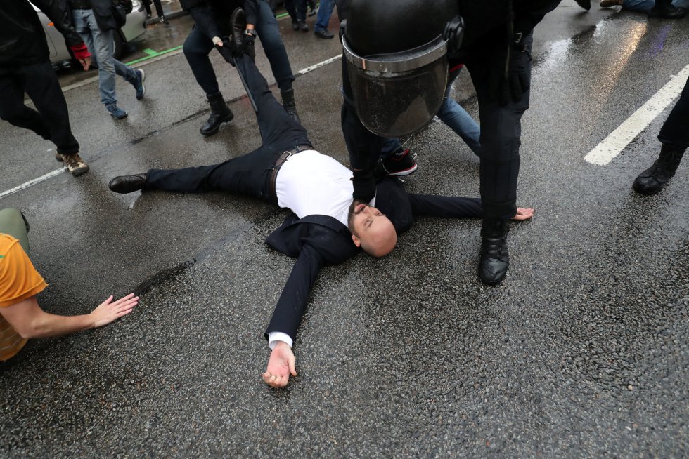 Un hombre es inmovilizado por un oficial de la Guardia Civil en una manisfestación frente a un centro de votación en Barcelona.