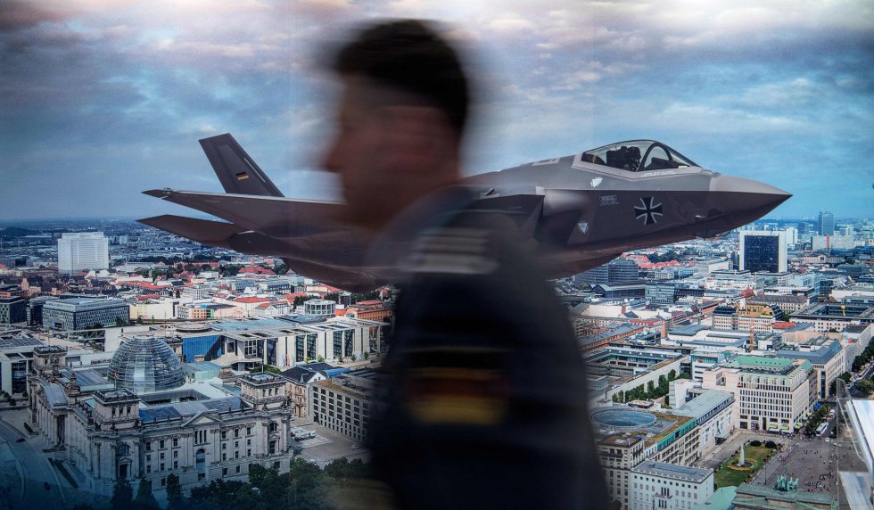 Un hombre pasa junto a un cartel que anuncia el caza F-35 de combate múltiple del fabricante de equipos de defensa estadounidense Lockheed Martin, durante la Conferencia de Seguridad de Berlín (Alemania).