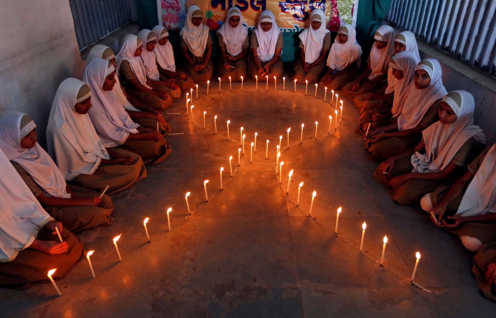 El Día Mundial de la Lucha contra el SIDA se celebra en todo el mundo el 1 de diciembre de cada año. En la imagen, estudiantes encienden velas durante el día contra el Sida en Ahmedabad, en 2016.