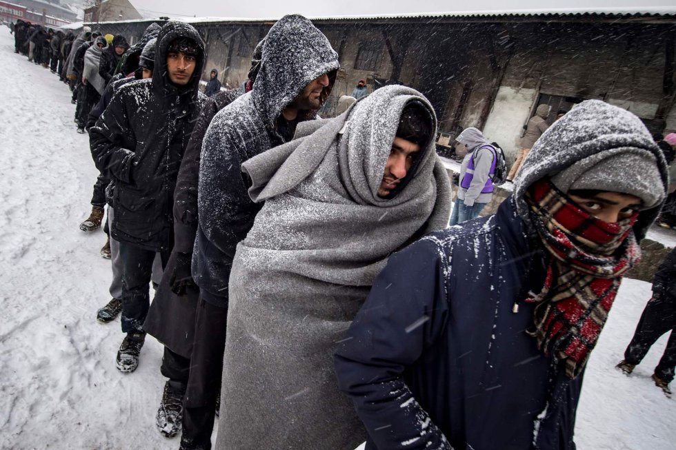 Inmigrantes esperan su turno para recibir la comida que reparten los voluntarios en un refugio de Belgrado (Serbia), el 11 de enero de 2017.